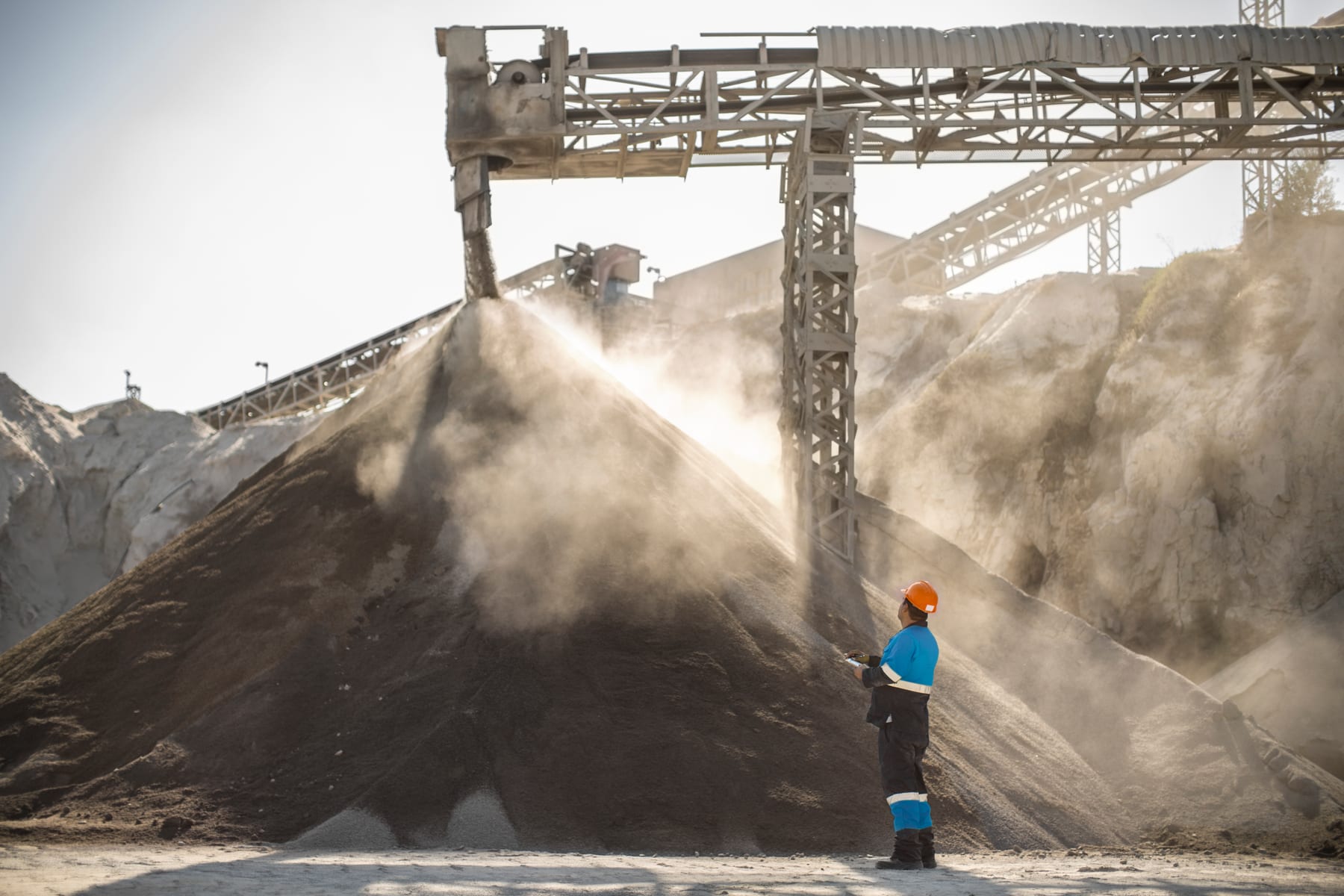 A mineworker beside an aggregate stockpile at a quarry