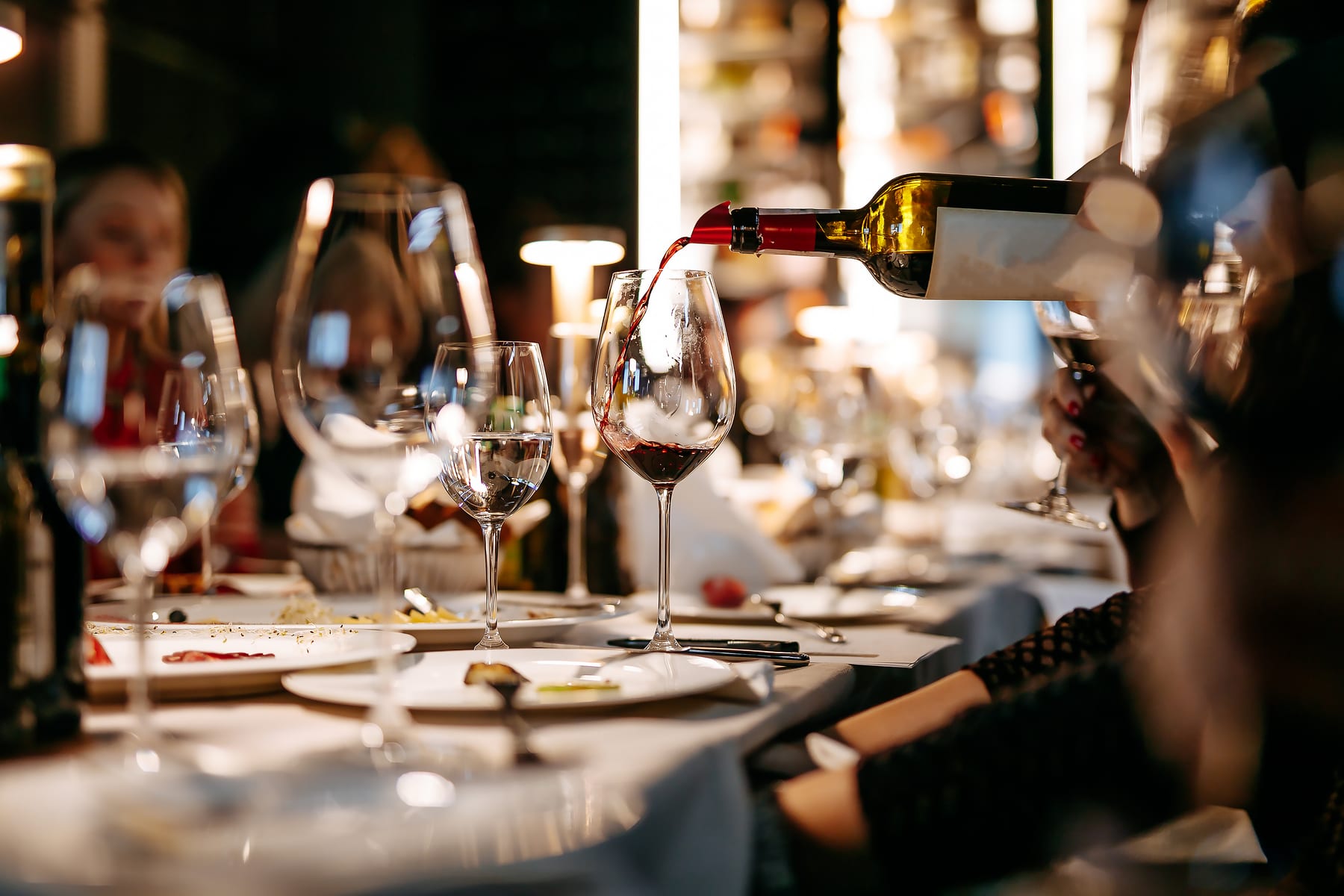 Red wine being poured at the table during the evening